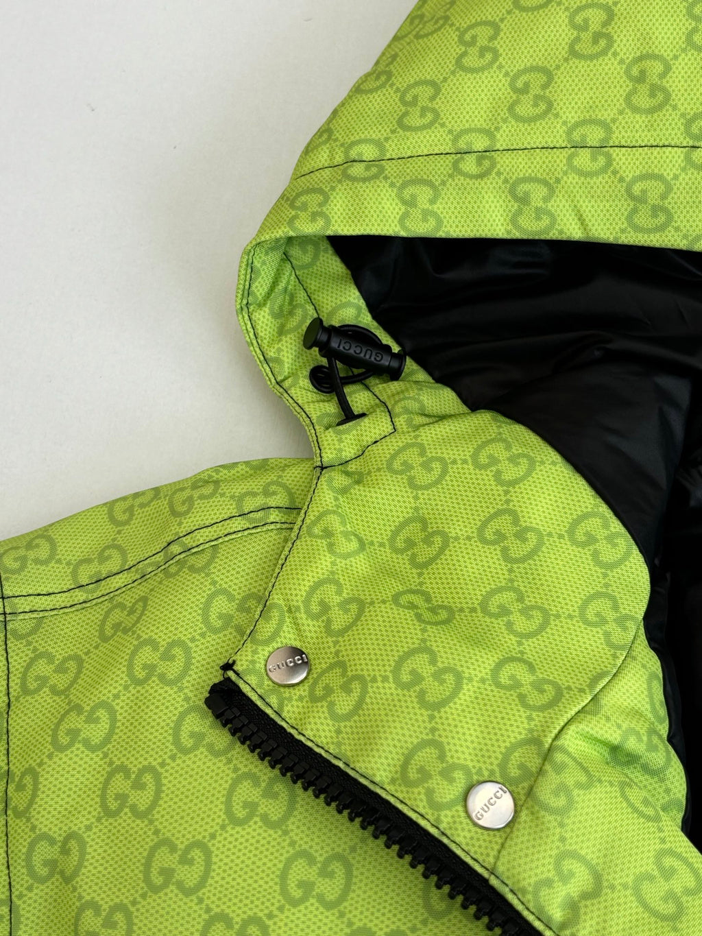 Lime green hooded puffer jacket with zipper and dark interior hood lining
