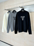 Long-sleeve crewneck sweaters on hangers: gray and black, PRADA logo