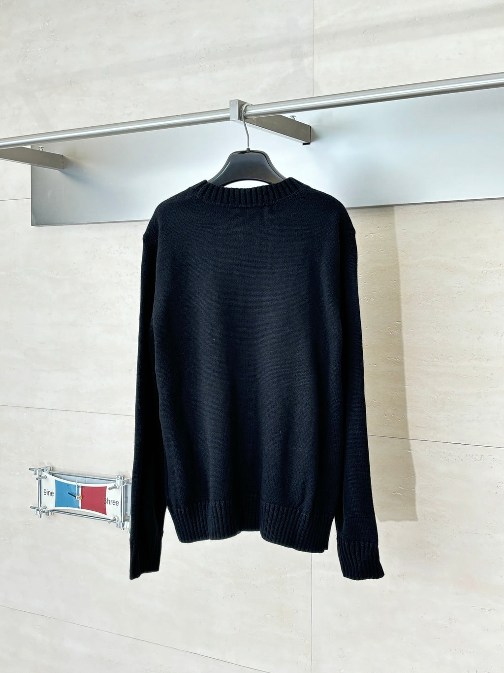 Black long-sleeve crewneck sweater, back view, ribbed hem and cuffs