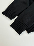 Black rib-knit sweater cuffs and sleeves with vertical rib texture