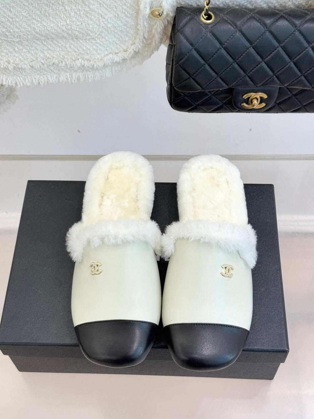 Chanel women's fur slides, cream footbed with black trim, gold logo on strap
