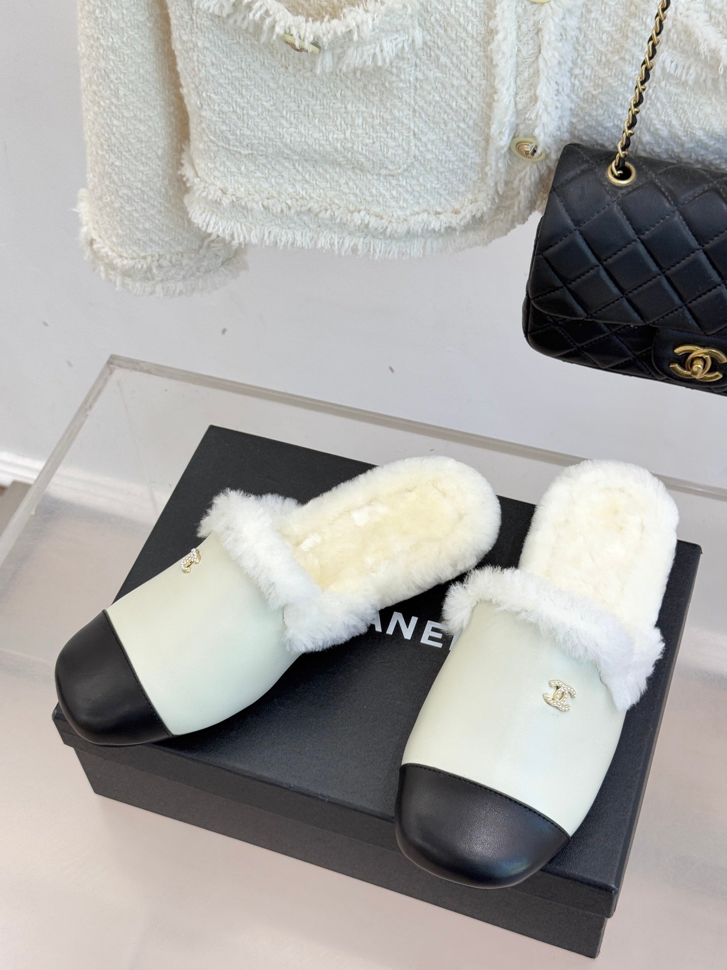 Chanel women's slides pair, cream fur lining, black toe strap, gold logo
