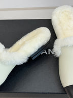Chanel women's fur slide close-up, cream upper with black sole, gold logo