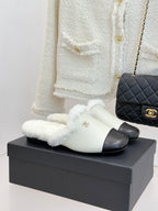 Chanel women's slides with white fur strap and black band, gold logo detail