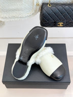 Chanel women's slides on black box, cream fur strap, black outsole with icons