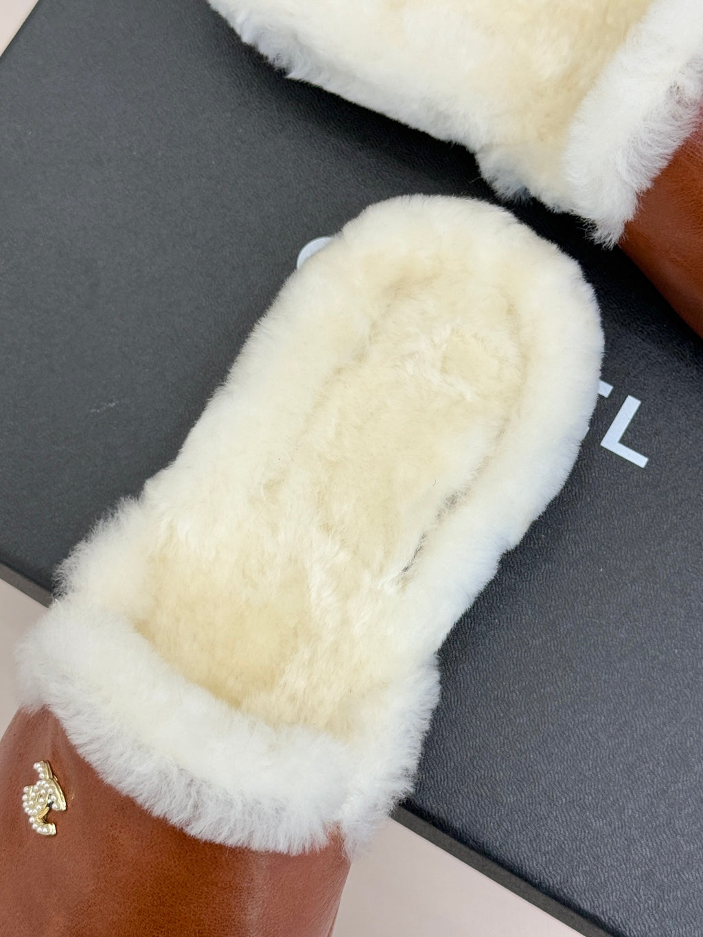 White shearling band on brown leather mule slipper with small gold Chanel logo