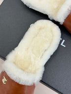 White shearling band on brown leather mule slipper with small gold Chanel logo