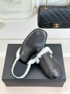 Black leather mule pair with white shearling trim and visible sole embossing