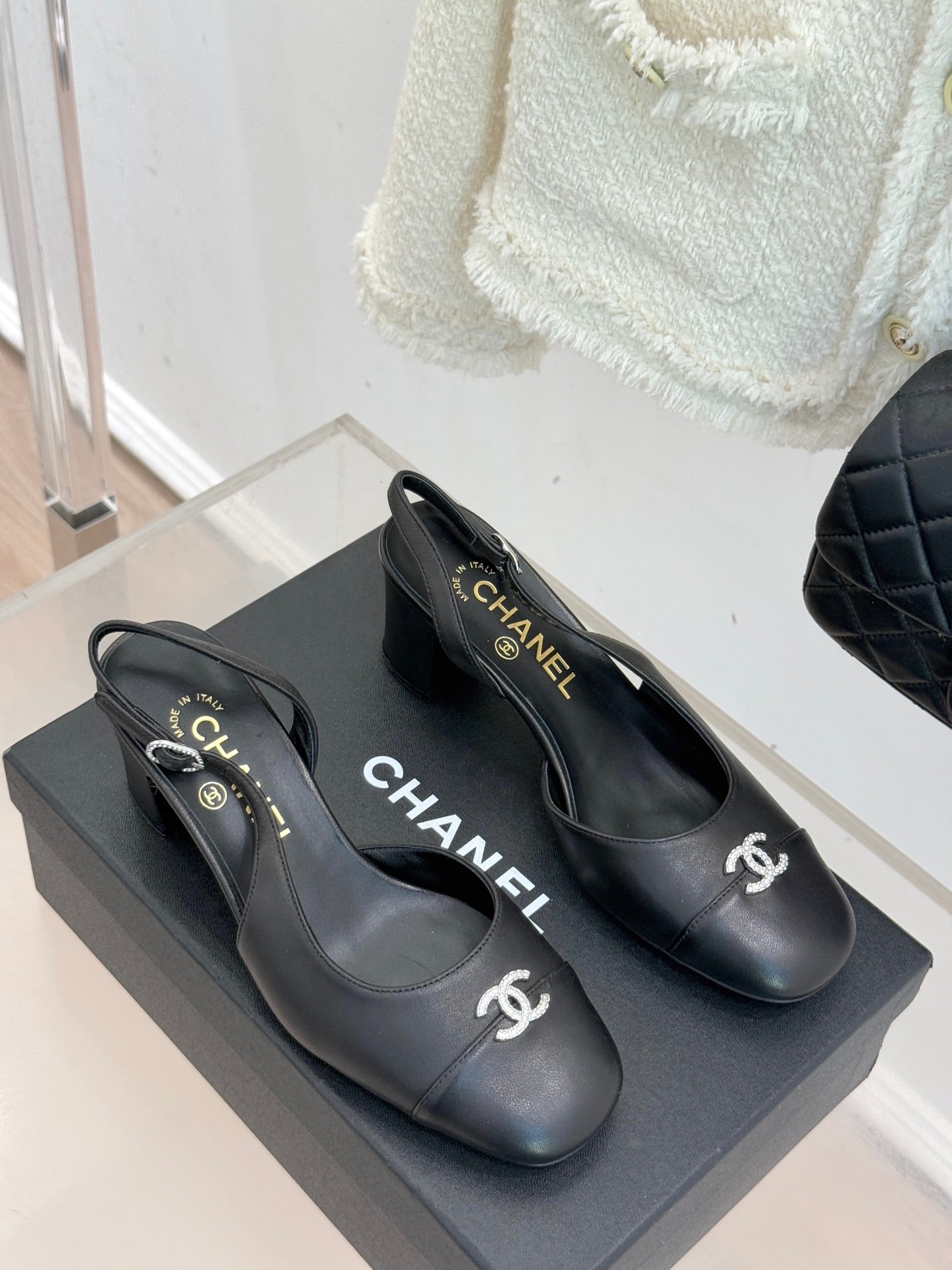 Pair of black leather slingback heels with round toe and CHANEL logo on sides