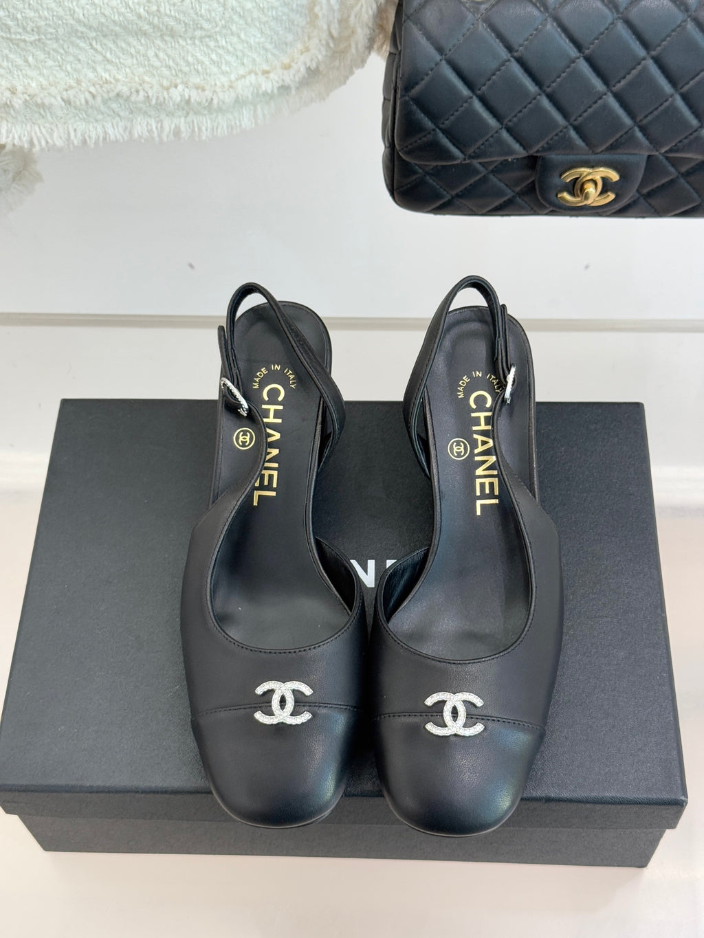 Black leather slingback heels with CHANEL logo at toe and on heel cup