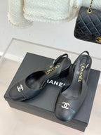 Black leather slingback heels on a box with CHANEL logo on straps and insoles