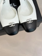 Women's two-tone leather mules close-up, bow hardware at front with dark toe caps