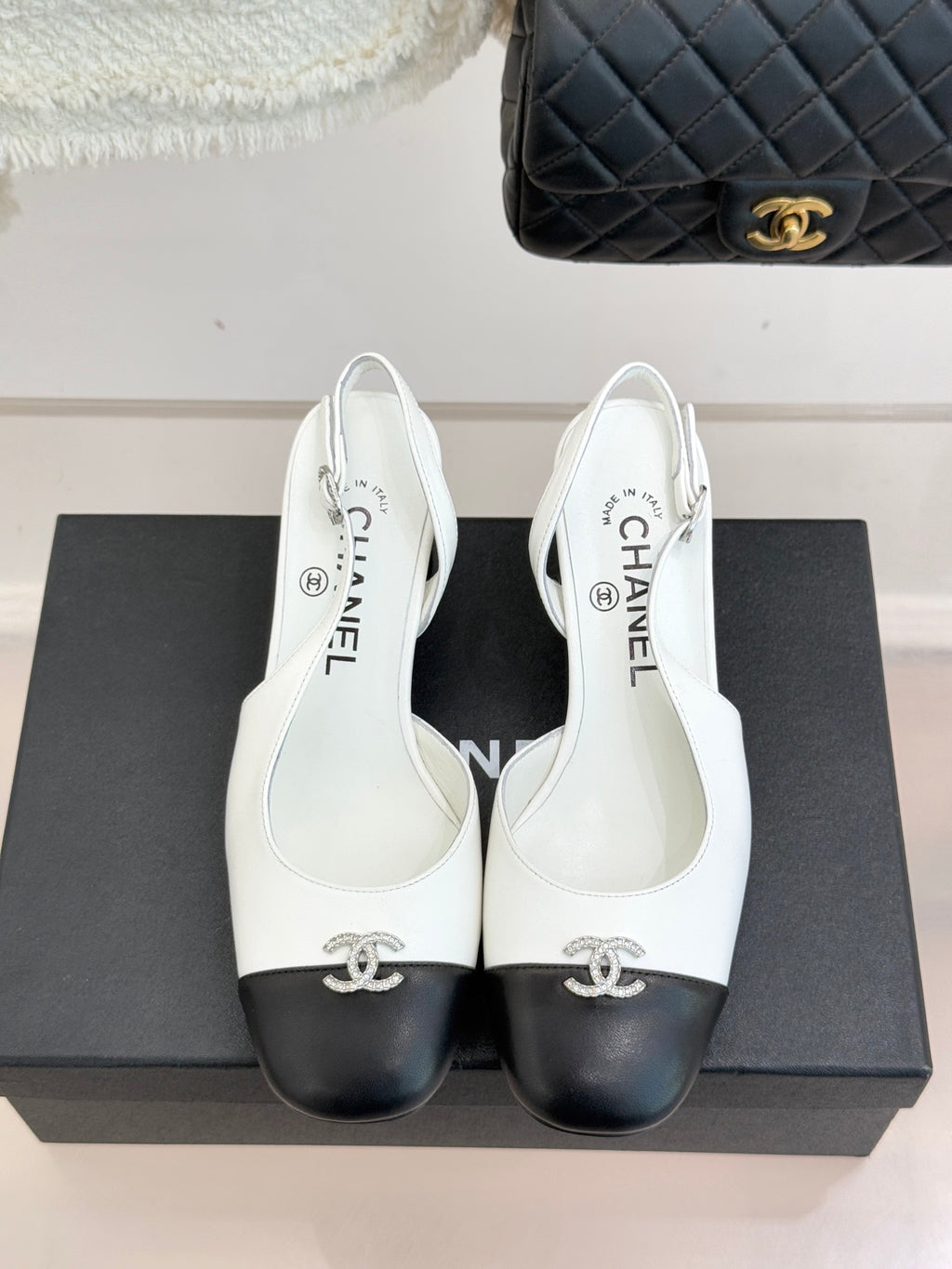 Women's two-tone leather mules with bow ornament, white uppers and dark rounded toe caps