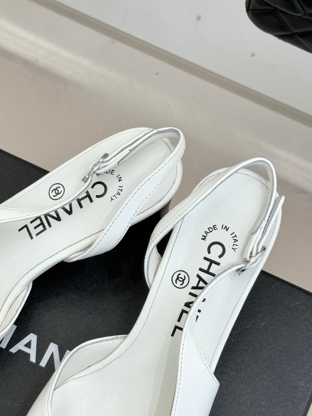 Women's white leather mules close-up, insole text and back opening with logo