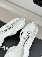 Women's white leather mules close-up, insole text and back opening with logo