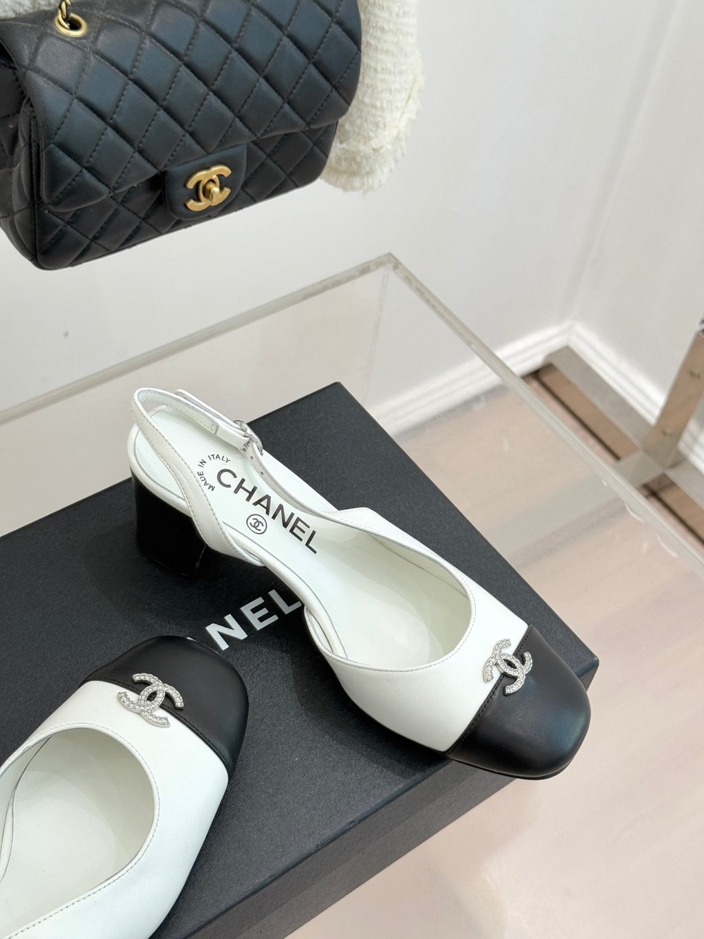 Women's two-tone leather mules, side view; white insole text and dark toe caps