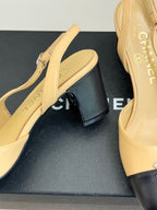 Women's Chanel slingback heel close-up, beige upper with black heel cap and CC detail.