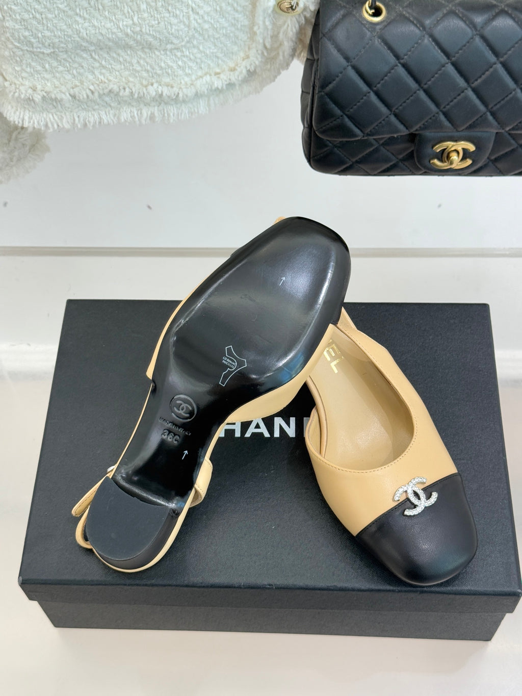 Women's Chanel two-tone slingback heels, beige uppers with black soles and CC emblem.