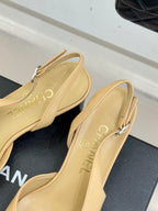 Women's Chanel slingback heels heel view, beige uppers with black toe caps, front strap.