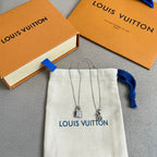 Two silver padlock charm necklaces with chain on white drawstring pouch