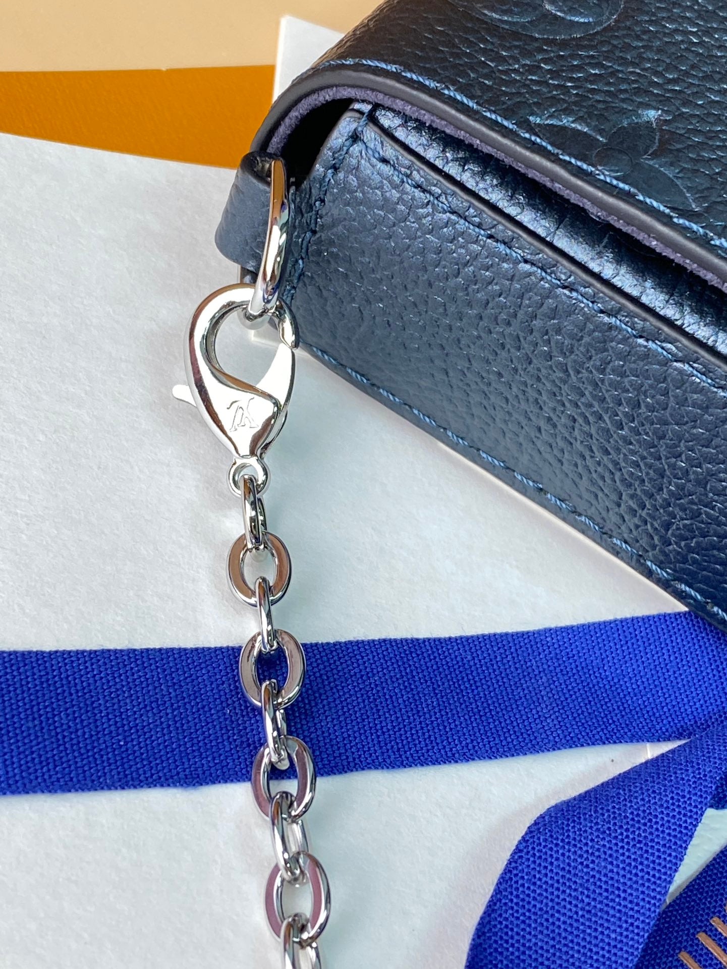 Blue leather bag with silver chain strap and metal clasp