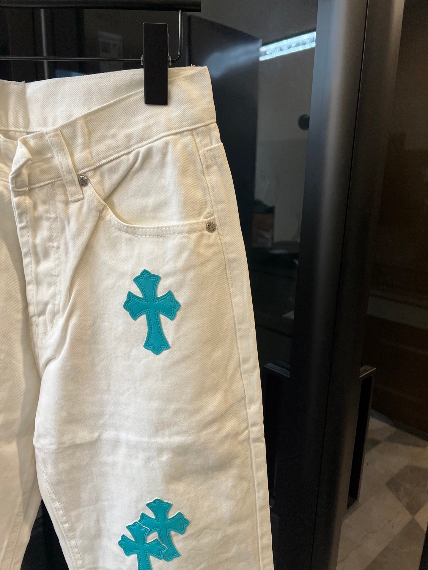 Chrome pants in white with teal cross print, front pocket and curved seam