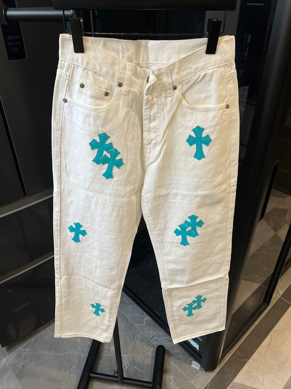 Chrome pants in white with teal cross print, button-front and belt loops