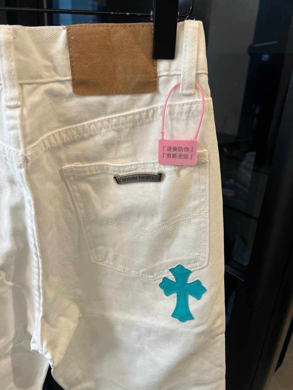 Chrome pants in white with teal cross print, side pocket and pink hang tag