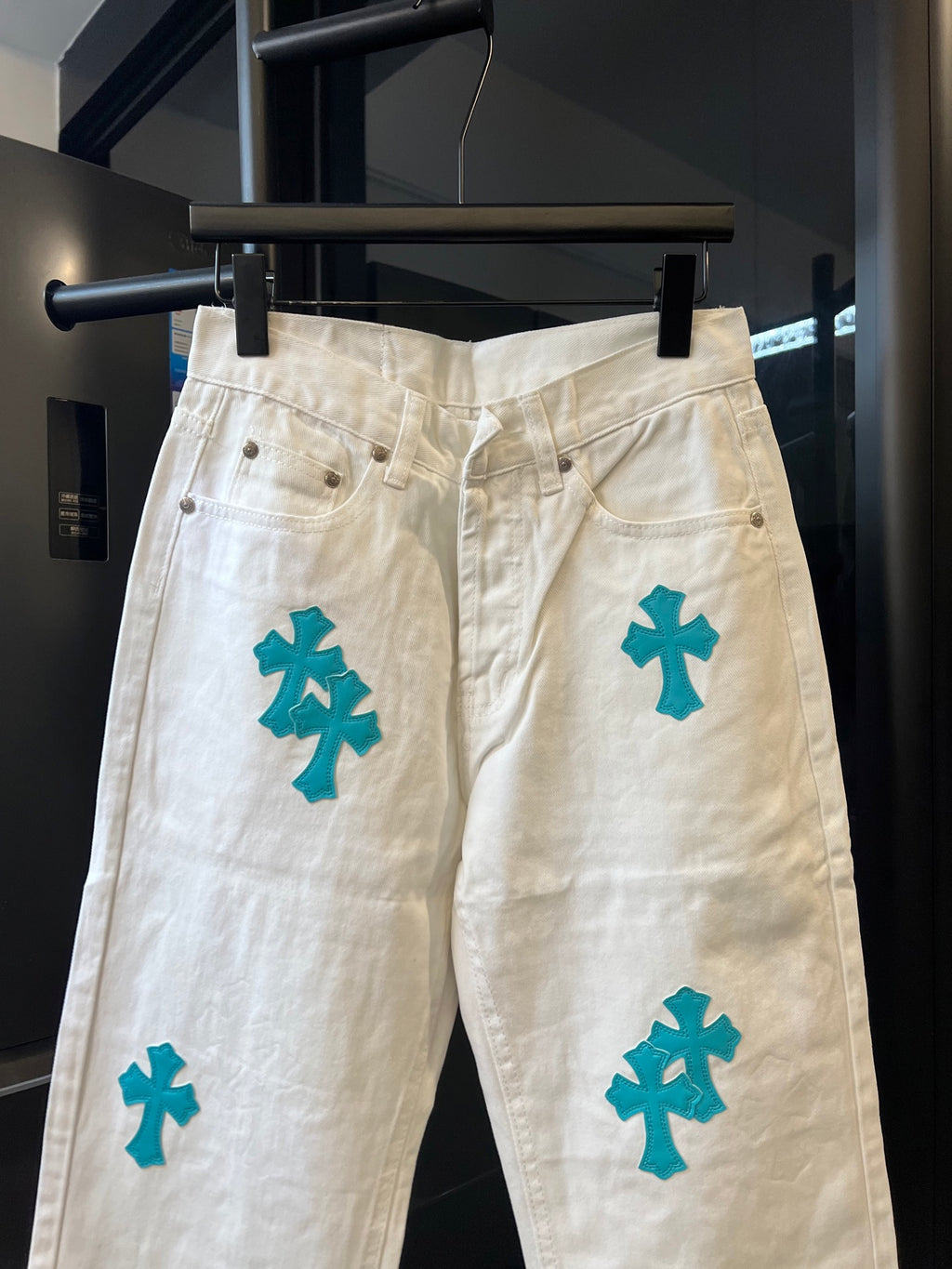 Chrome pants in white with teal cross print, high-rise waistband and belt loops