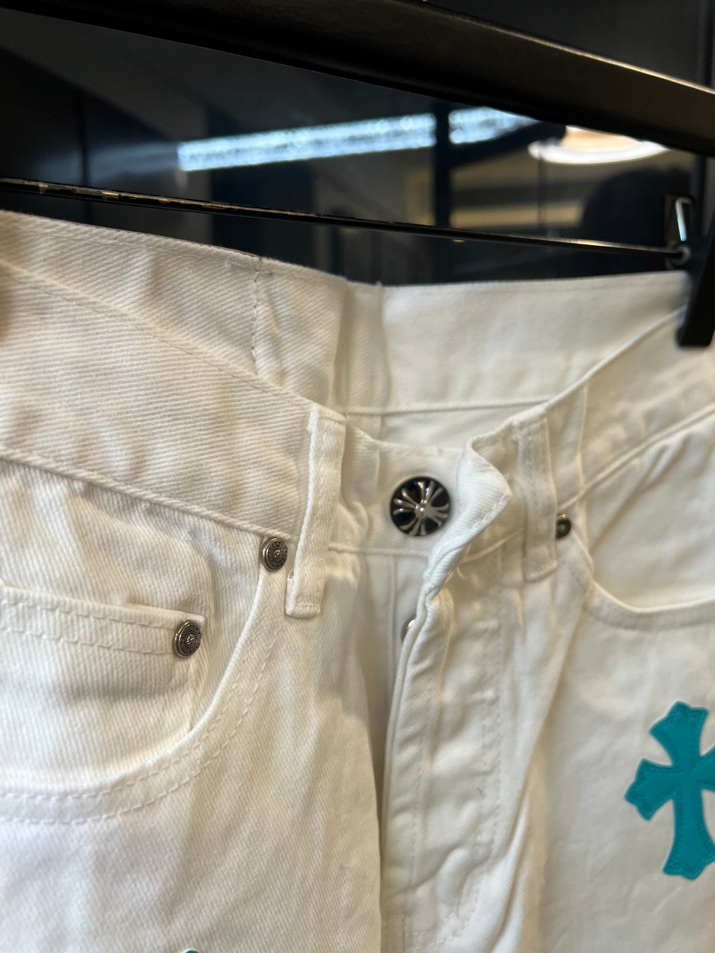 Chrome pants in white with teal cross print, metal button closure and zip fly