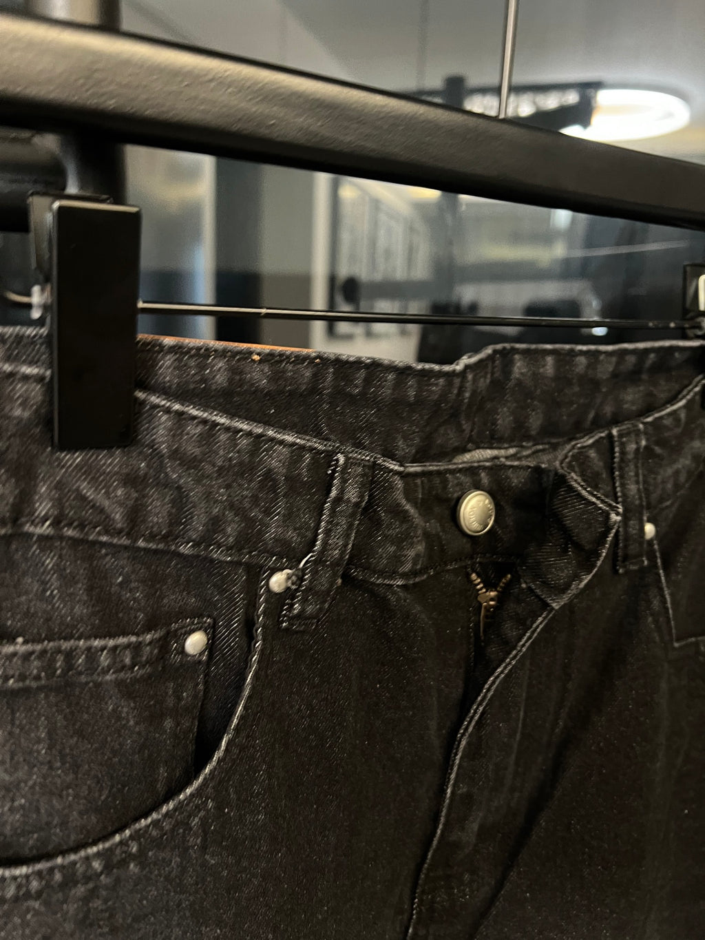 Dark denim waistband with belt loops and silver-tone button at the front