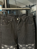Dark denim jeans with front button, pocket stitching, and white monogram hem band