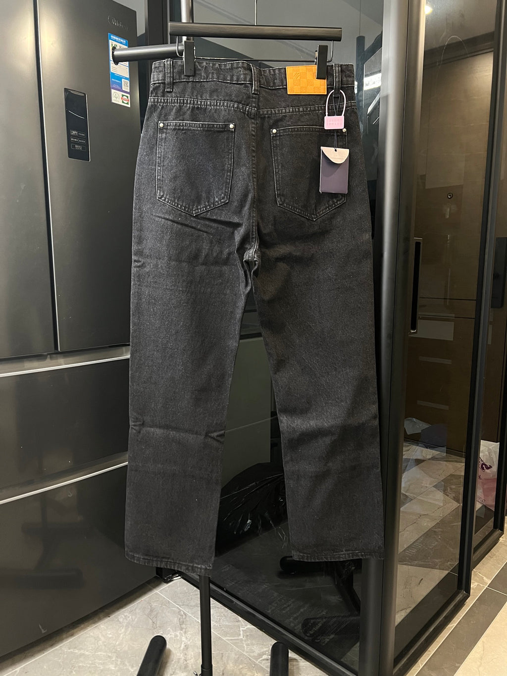 Dark denim jeans with five-pocket styling and silver-tone buttons