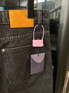 Dark denim pants with front pocket and hanging brand tags