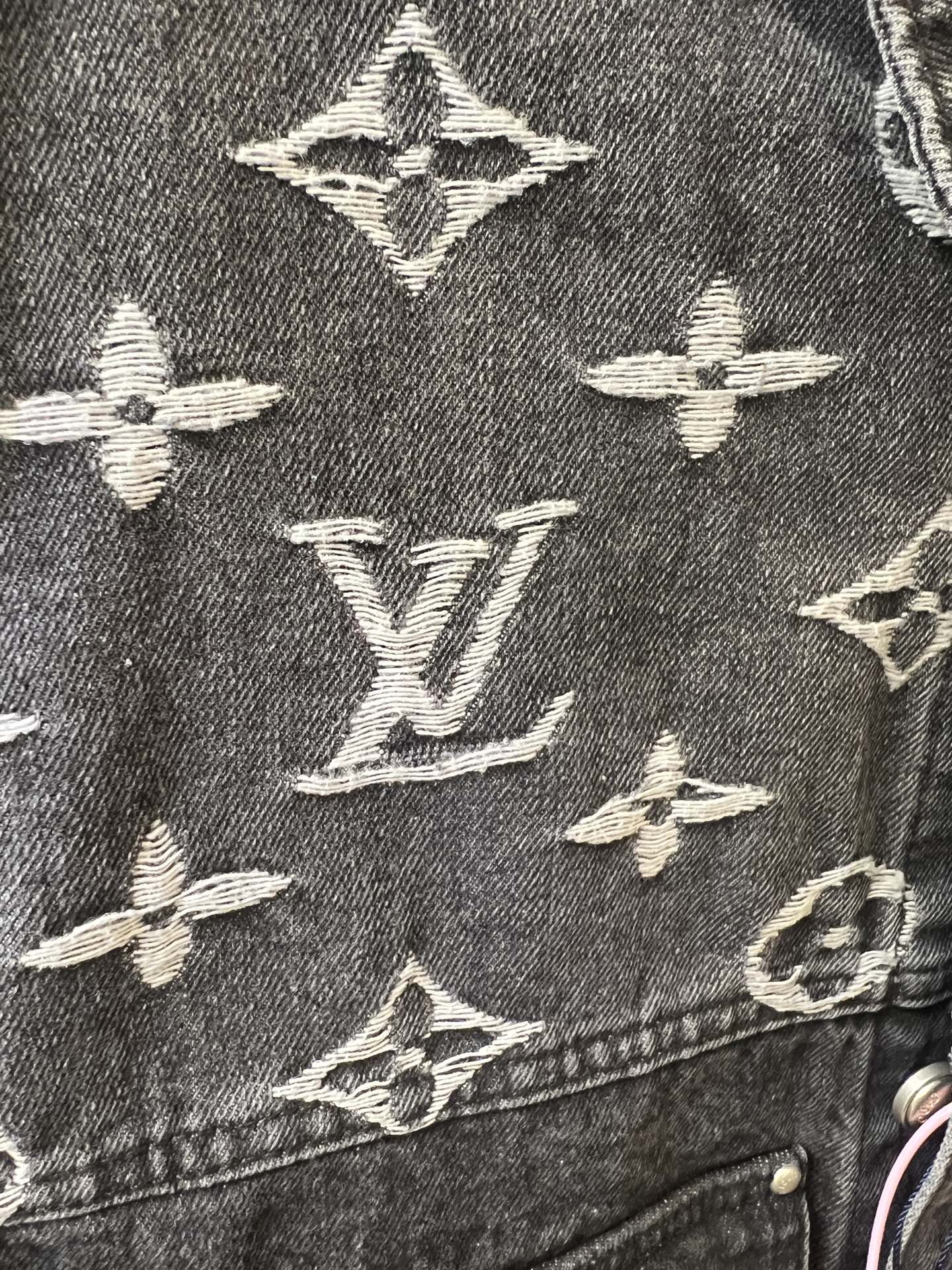 Close-up of denim jacket monogram pattern, dark gray with cream Louis Vuitton icons