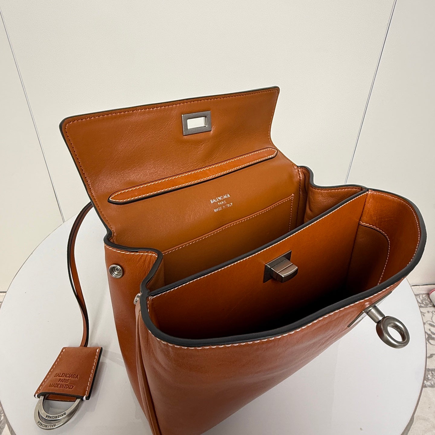 Balenciaga brown leather handbag open top showing interior and front clasp
