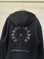 Black zip-up hoodie back view with large circular embroidery and decorative arched text.