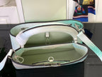 Open light blue crocodile-embossed handbag showing green interior lining