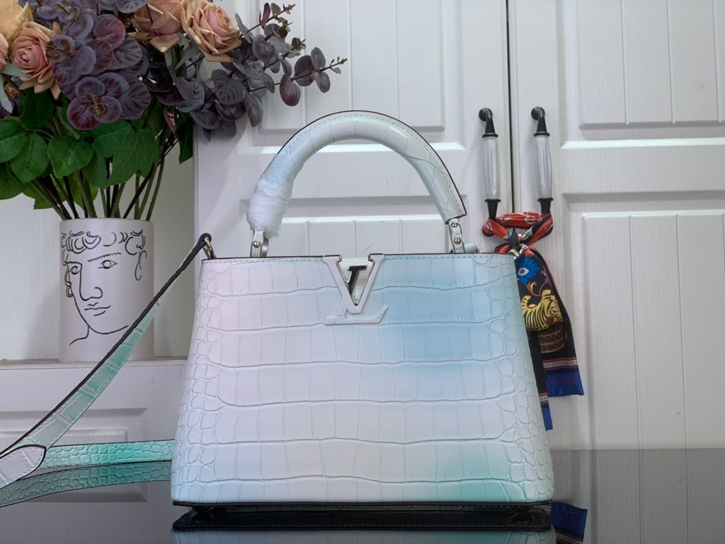 Light blue crocodile-embossed handbag with top handle and structured front panel