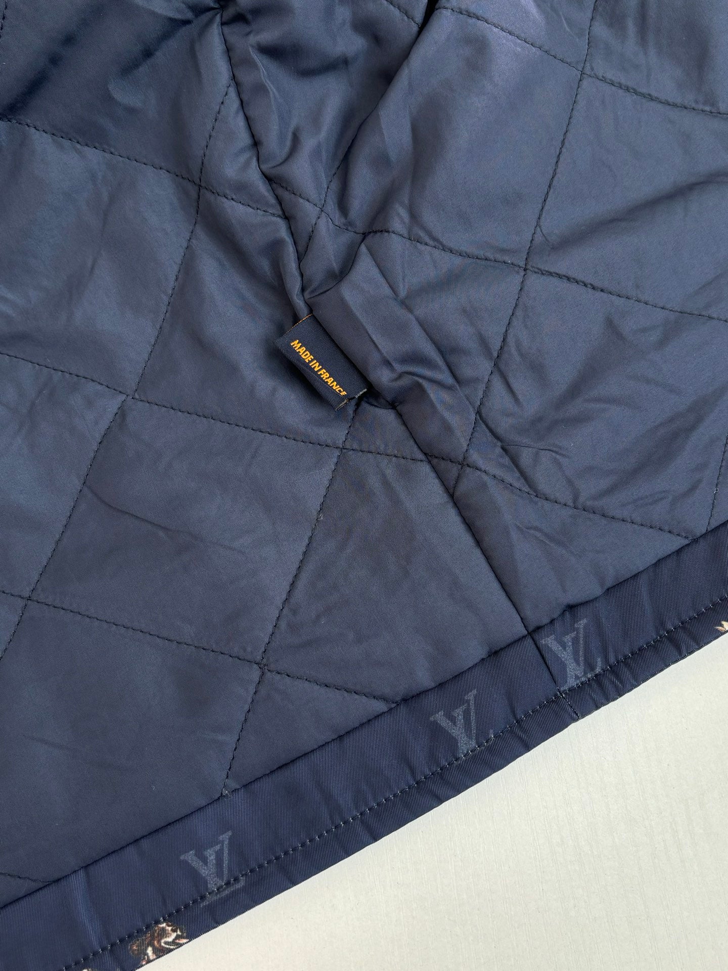 Louis Vuitton quilted long jacket in dark blue with tonal monogram print and cuff trim