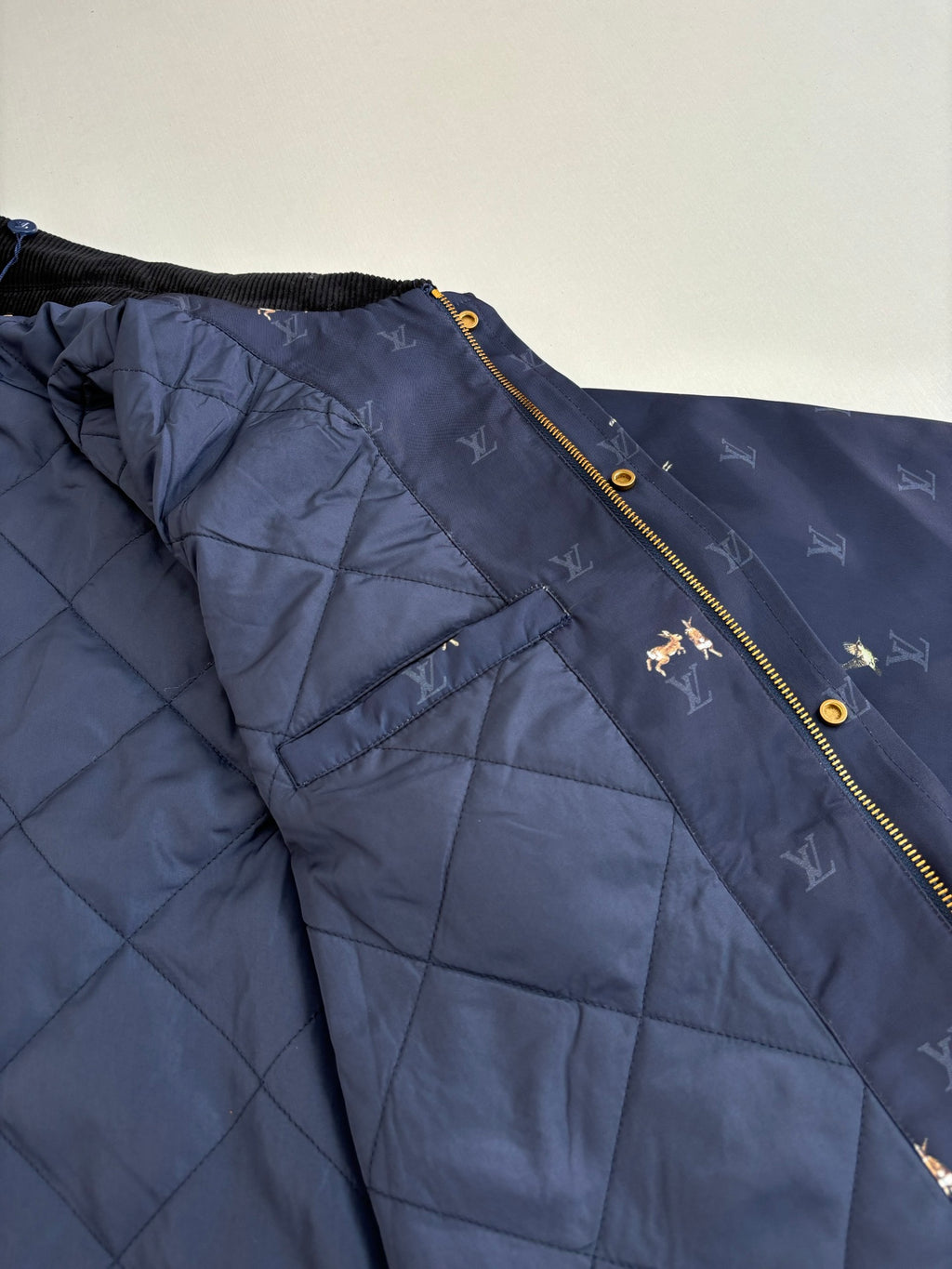 Navy Louis Vuitton puffer lining with quilted panels and gold zipper edge
