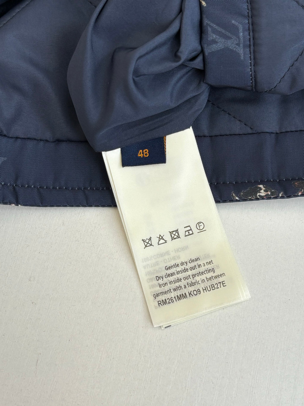 Louis Vuitton long quilted jacket care label and size tag on navy fabric