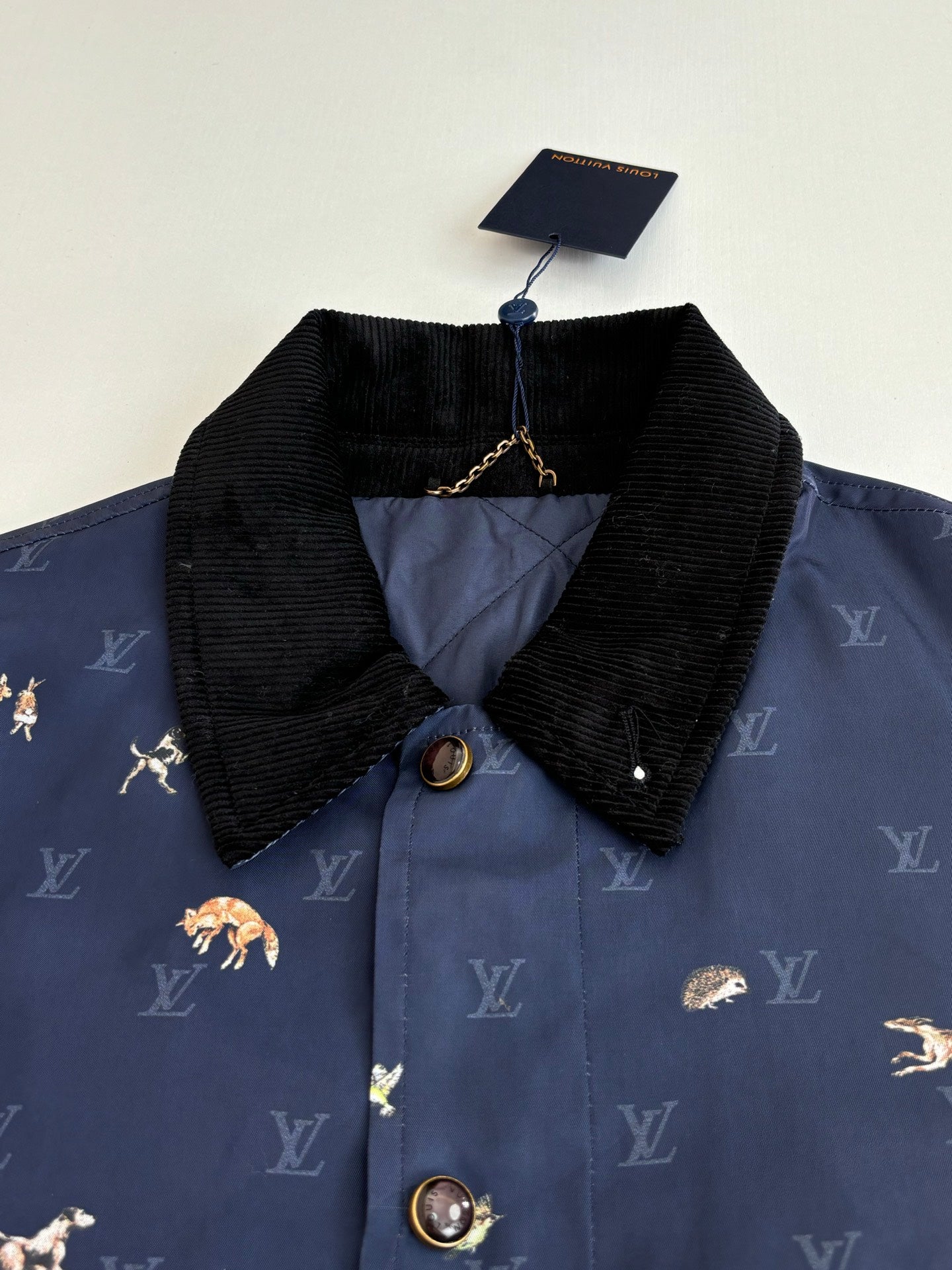 Navy Louis Vuitton jacket with black corduroy collar and gold button details