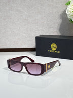 Versace sunglasses with burgundy frames, gold temple accents, and dark tinted lenses