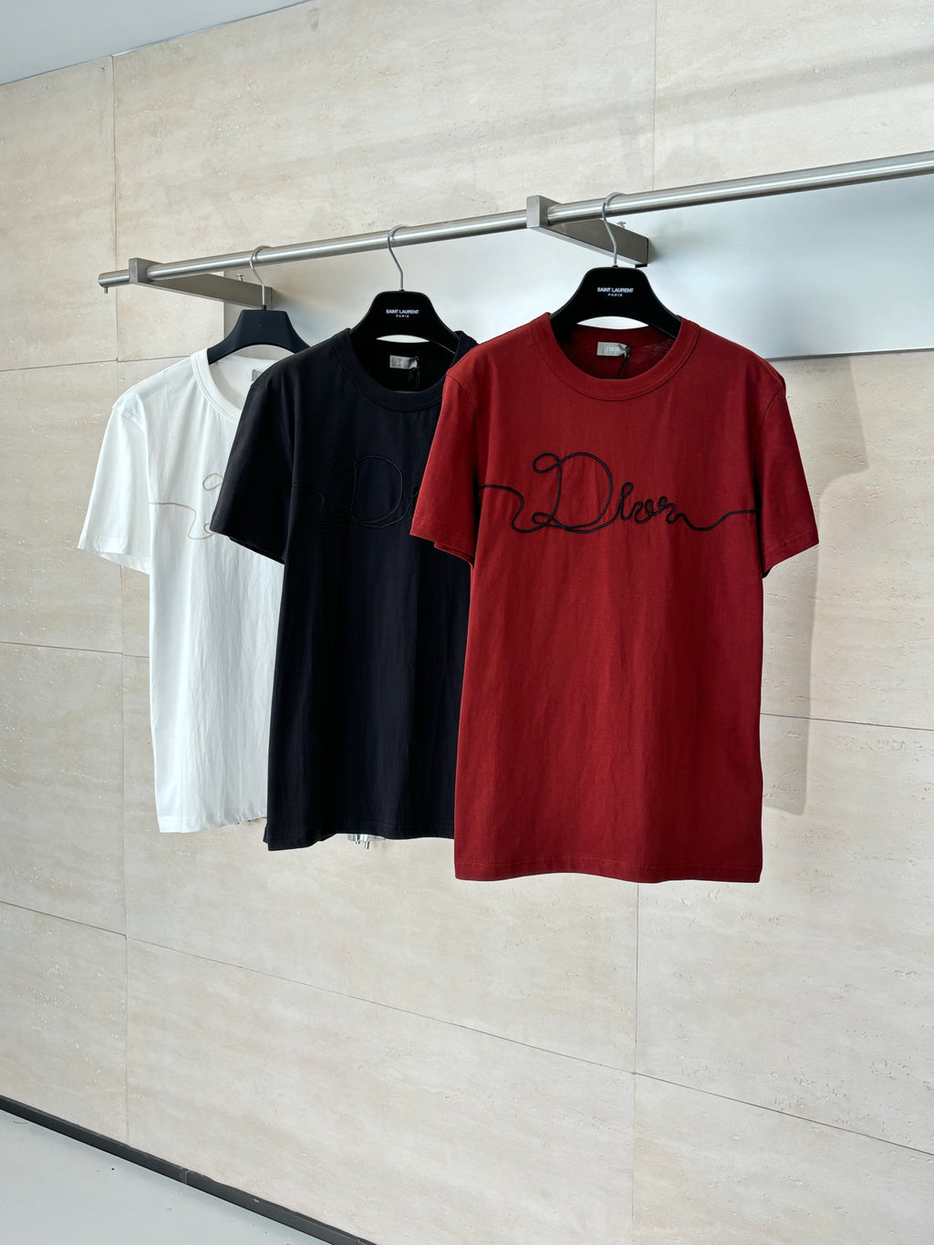 Dior short-sleeve T-shirts on hangers: red, black, and white