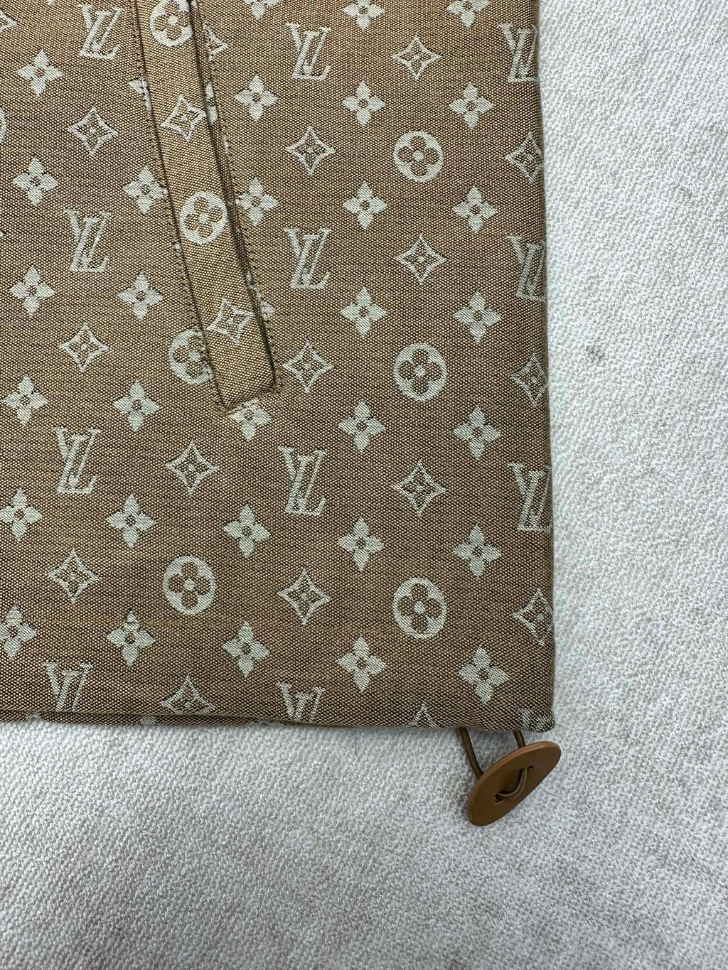 Brown monogram jacket sleeve detail with cuff and small button tab