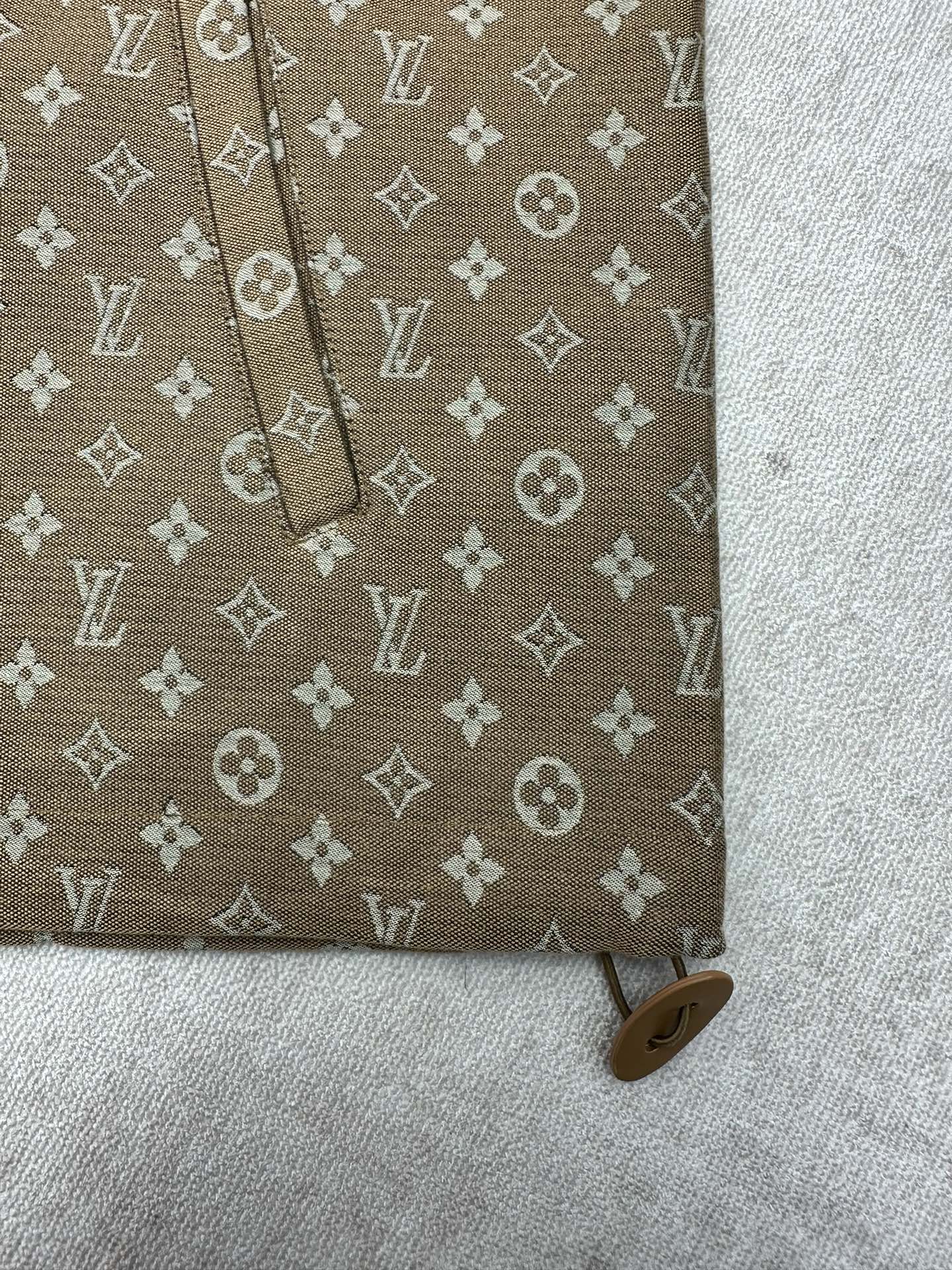 Brown monogram jacket sleeve detail with cuff and small button tab