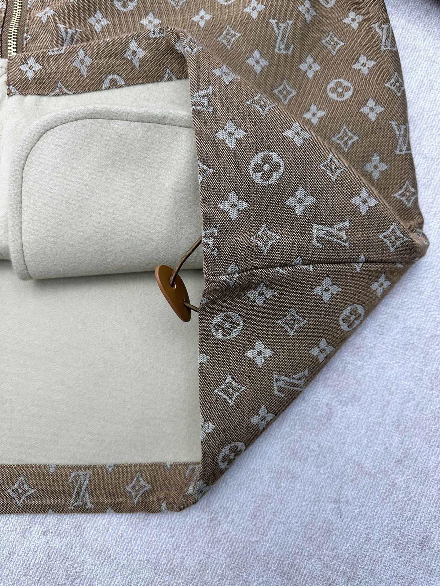 Jacket interior lining with beige fabric and zipper edge view