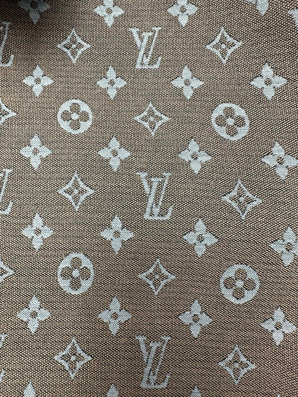 Monogram pattern fabric close-up in brown with light-beige motifs
