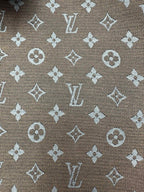 Monogram pattern fabric close-up in brown with light-beige motifs